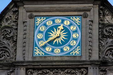 Beautiful blue clock with gold elements on the roof of the building.