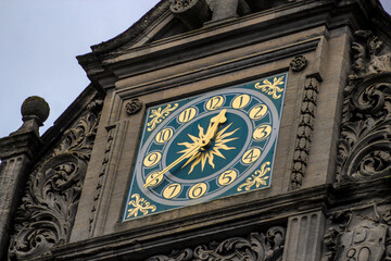 Beautiful blue clock with gold elements on the roof of the building.