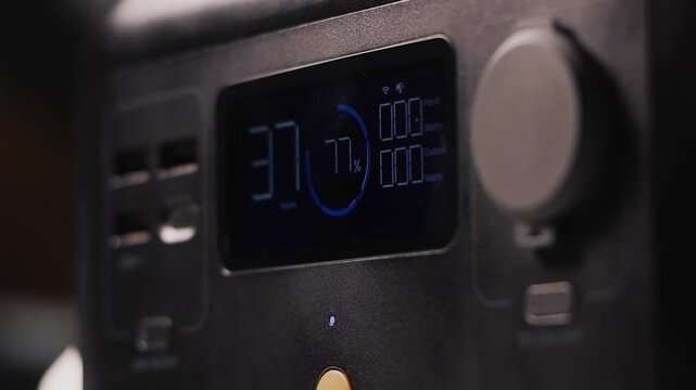 The screen displays remaining battery percentage, input and output wattage, and temperature in Celsius, indicating operational data