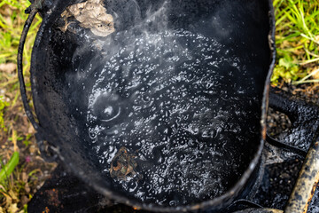 boiling tar in a pitch pot with steam 