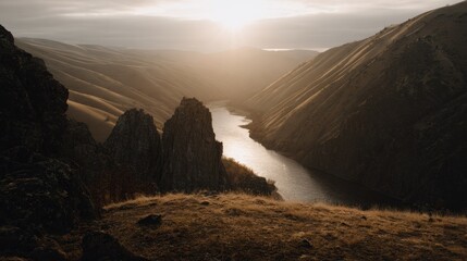 Dramatic sunlight bathes a rugged river canyon landscape at sunrise or sunset