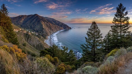 Majestic coastal mountains meet the ocean waters during a vibrant sunset