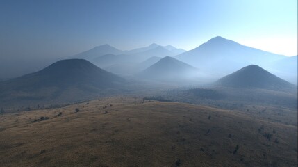 Multiple volcanic cones recede into layers of atmospheric haze under a clear blue sky