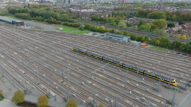 Ascending aerial view over a Dutch train depot as a single unveiling the Utrecht skyline and rail infrastructure