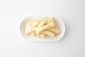 Plain Korean Rice Cakes on White Plate Isolated on White Background 흰 접시에 담긴 떡볶이용 가래떡