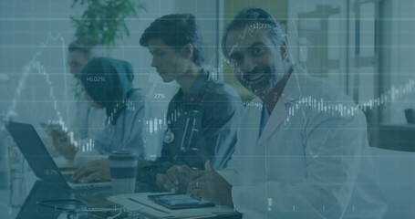 Smiling doctor in lab coat using tablet in clinic meeting, stethoscope, stock overlay, copy space