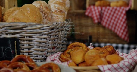 Displaying woven wicker basket holding crusty loaves at market stall, checked cloths, pastries