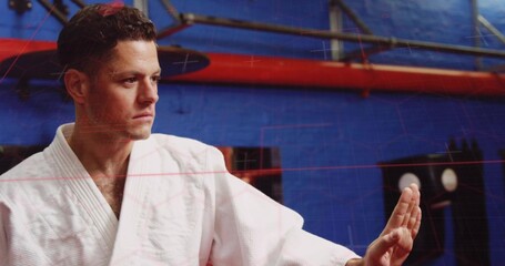 Blocking man wearing white martial-arts gi extending open palm in dojo with red beam, copy space