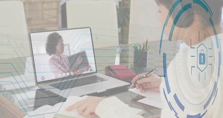 Taking notes boy at home desk, laptop showing tutor in pink blouse, security overlay, copy space