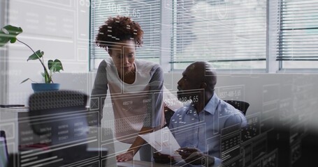Discussing man in collared shirt holding paper with woman in blouse at office, monitor overlays