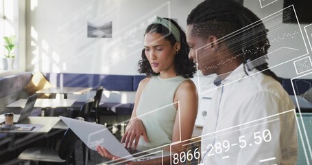 Holding laptop, two coworkers in sleeveless top and white shirt pointing at screen at cafe, AR