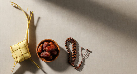 Islamic Ramadan and Eid al-Fitr Concept with Ketupat, Dates Fruit, and Prayer Beads on Textured Background with Copy Space.
