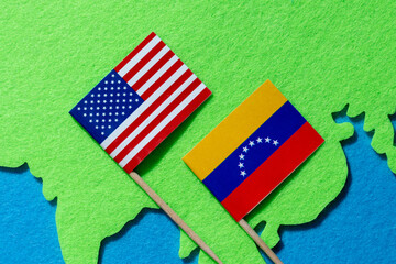 National flags of the United States and Venezuela placed on a world map. International relations, geopolitical tensions, trade and conflict concept.