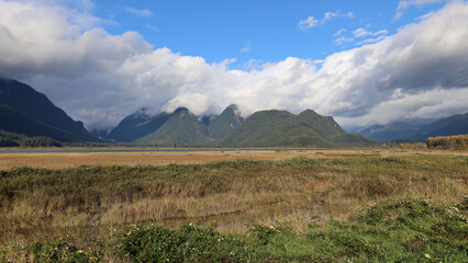 Autumn panorama with grassy field and mountains