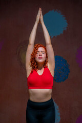 A woman in a red tank top is doing yoga poses