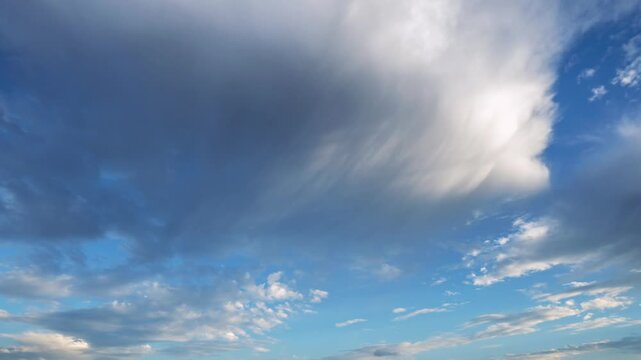 Time-lapse of summer sky with dramatic clouds and virga&mdash;rain that evaporates before reaching the ground, showcasing dynamic weather patterns against a vivid blue backdrop.