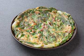 Korean Chive Pancake (Buchujeon) on Dark Stone Background 어두운 배경 위에 담긴 한국식 부추전