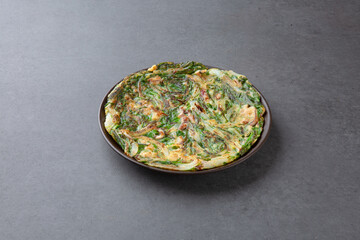 Korean Chive Pancake (Buchujeon) on Dark Stone Background 어두운 배경 위에 담긴 한국식 부추전