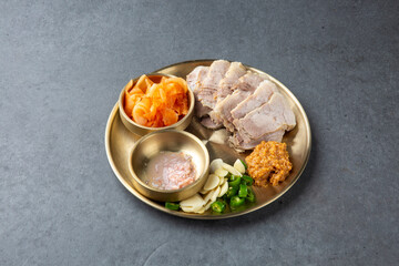 Korean Boiled Pork Belly with Traditional Side Dishes on Brass Plate 전통 놋접시에 담긴 한국식 보쌈 한상