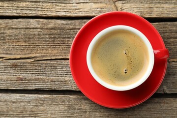 Cup of aromatic coffee on wooden table, top view. Space for text