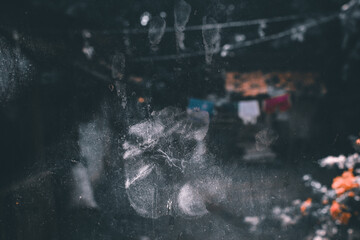A palm print on a dirty, dusty glass surface with a dark, blurry background. The fingerprint is clearly visible.