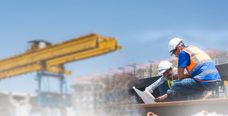 Engineers reviewing construction plans at railway infrastructure site, Construction safety...