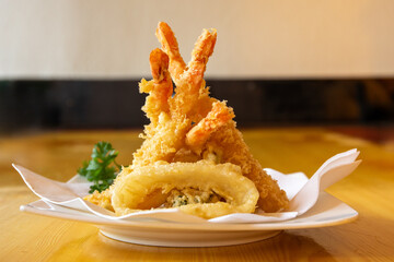 Tempura battered shrimp on a plate with a single squid ring