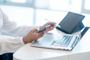 hands of woman woking on labtop and smartphone checking for data