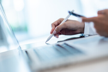 business woman working on smartphone labtop and pointing pen on talbet