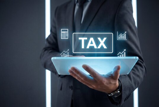 Businessman holding tablet with digital tax concept and financial graphs for accounting management - Powered by Adobe