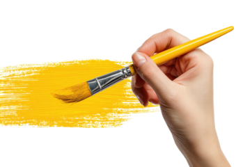 Hand painting a broad yellow stroke with a brush on a black background