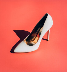 White Patent Leather Stiletto Pump on Vibrant Red Background, Bold Minimalist Fashion Product Photography with Hard Shadow