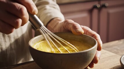 Close Up of Person Whisking Yellow Liquid in Bowl in Kitchen