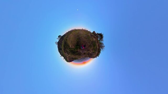Person hiking on tiny planet at sunrise