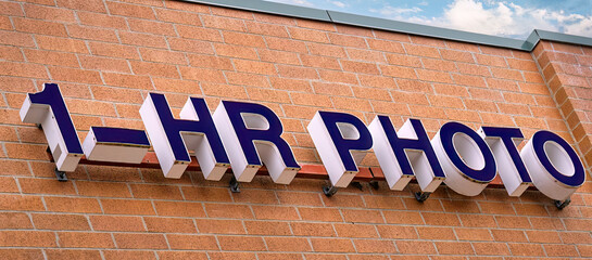 One hour photo sign on a brick building.