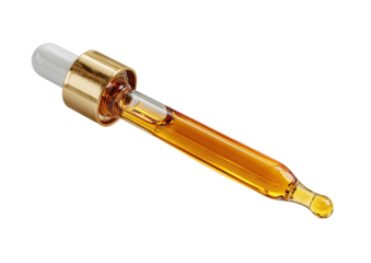 Golden liquid in glass pipette with gold cap, isolated on black background