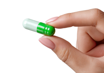 Hand holds a green & white capsule against black