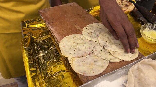A man preparing masala Kulcha in a Tandoor in a wedding in India