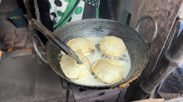 A street food seller cooking fresh matar kachori in a roadside stall in Kolkata, India