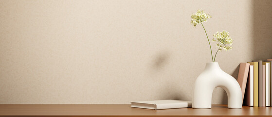 Unique design flower vase and books on wooden&nbsp;counter table&nbsp;with sunlight shining on beige loft wall