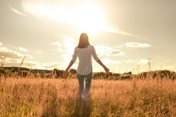 Young joyful woman outdoors with arms outstreched finding inner strength peace in nature	