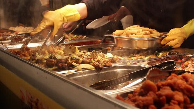 Chinese fast food buffet worker refilling the food trays
