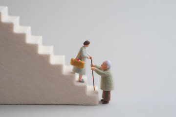 階段を上る高齢者を優しく支える少女の思いやり（フェルト・3D）まみおデザイン福祉シリーズ
