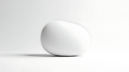 A single white egg rests on a clean reflective white surface