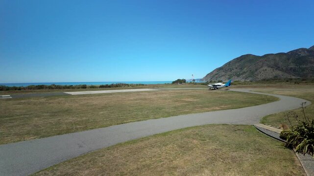 Light airplane turning toward runway at seaside airfield