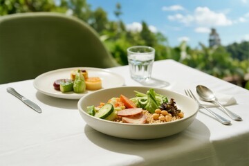 A healthy meal with vegetables, grains, and legumes served on a white tablecloth outdoors under sunlight