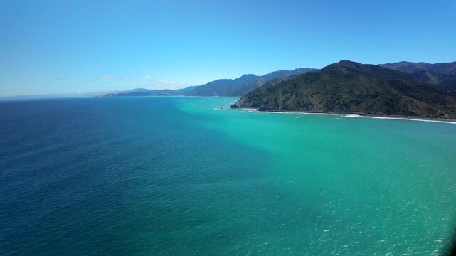 Helicopter view of turquoise ocean and rugged coastline