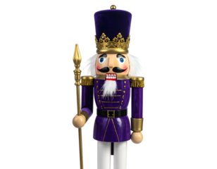 A decorative purple toy soldier nutcracker with crown and staff against a dark backdrop