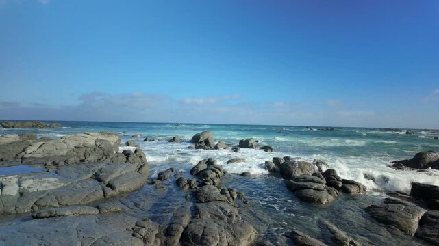 Waves crashing over rocky reef at low tide