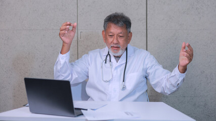 Senior doctor feeling frustration looking at laptop screen stressed with bad news failure or technical issue while working in medical office